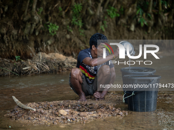 A tribal man collects water from the reservoir, locally known as ''Jhiri,'' in Durgapur, Netrokona, Bangladesh, on November 17, 2024. The re...