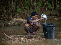 A tribal man collects water from the reservoir, locally known as ''Jhiri,'' in Durgapur, Netrokona, Bangladesh, on November 17, 2024. The re...