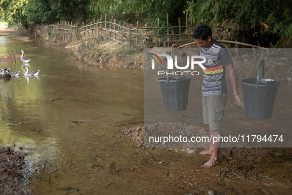 A tribal man collects water from the reservoir, locally known as ''Jhiri,'' in Durgapur, Netrokona, Bangladesh, on November 17, 2024. The re...