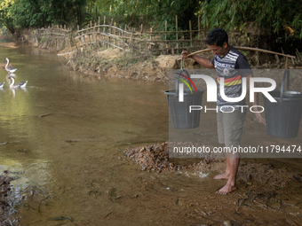 A tribal man collects water from the reservoir, locally known as ''Jhiri,'' in Durgapur, Netrokona, Bangladesh, on November 17, 2024. The re...