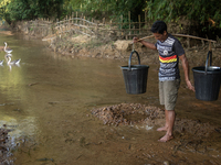 A tribal man collects water from the reservoir, locally known as ''Jhiri,'' in Durgapur, Netrokona, Bangladesh, on November 17, 2024. The re...