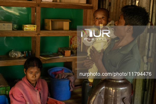 A man takes a break with his wife and children from making tea at his local tea stall in Durgapur, Netrokona, Bangladesh, on November 17, 20...