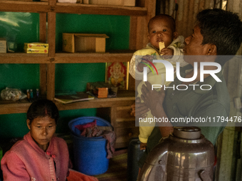 A man takes a break with his wife and children from making tea at his local tea stall in Durgapur, Netrokona, Bangladesh, on November 17, 20...