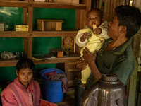 A man takes a break with his wife and children from making tea at his local tea stall in Durgapur, Netrokona, Bangladesh, on November 17, 20...