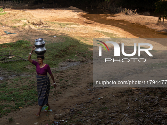 A tribal woman collects water from the reservoir, locally known as ''Jhiri,'' in Durgapur, Netrokona, Bangladesh, on November 17, 2024. The...