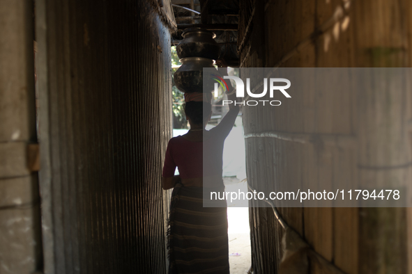 A tribal woman heads home after collecting water from the reservoir, locally known as ''Jhiri,'' in Durgapur, Netrokona, Bangladesh, on Nove...