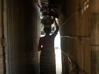 A tribal woman heads home after collecting water from the reservoir, locally known as ''Jhiri,'' in Durgapur, Netrokona, Bangladesh, on Nove...