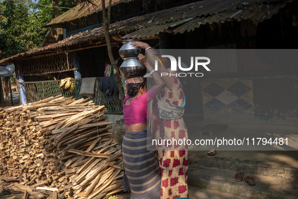 A tribal woman heads home after collecting water from the reservoir, locally known as ''Jhiri,'' in Durgapur, Netrokona, Bangladesh, on Nove...