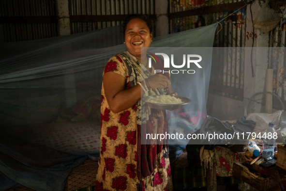 A tribal woman reacts to the camera as she eats her morning meal in Durgapur, Netrokona, Bangladesh, on November 17, 2024. 