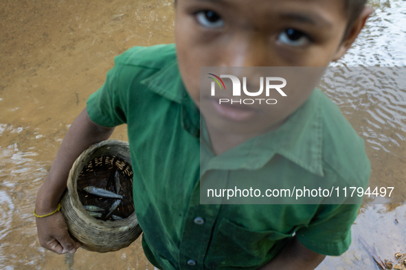 Indrajit (11) catches fish from the reservoir with a small net to support his family in Durgapur, Netrokona, Bangladesh, on November 17, 202...