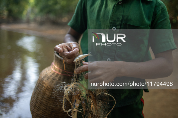 Indrajit (11) catches fish from the reservoir with a small net to support his family in Durgapur, Netrokona, Bangladesh, on November 17, 202...