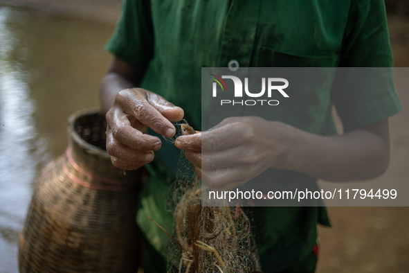 Indrajit (11) catches fish from the reservoir with a small net to support his family in Durgapur, Netrokona, Bangladesh, on November 17, 202...