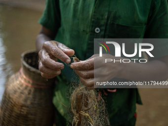 Indrajit (11) catches fish from the reservoir with a small net to support his family in Durgapur, Netrokona, Bangladesh, on November 17, 202...