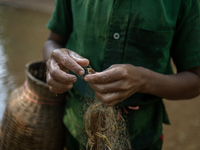 Indrajit (11) catches fish from the reservoir with a small net to support his family in Durgapur, Netrokona, Bangladesh, on November 17, 202...