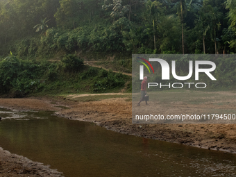 A tribal man collects water from the reservoir, locally known as ''Jhiri,'' in Durgapur, Netrokona, Bangladesh, on November 17, 2024. The re...