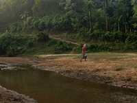 A tribal man collects water from the reservoir, locally known as ''Jhiri,'' in Durgapur, Netrokona, Bangladesh, on November 17, 2024. The re...