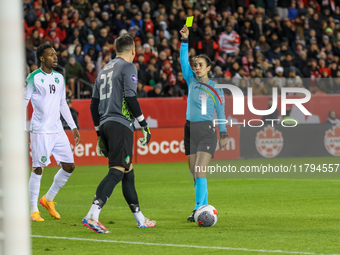 In Toronto, Ontario, Canada, on November 19, 2024, referee Katia Garcia shows a yellow card to Suriname goalkeeper E. Vaessen #23 during the...