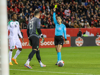 In Toronto, Ontario, Canada, on November 19, 2024, referee Katia Garcia shows a yellow card to Suriname goalkeeper E. Vaessen #23 during the...