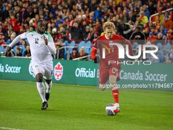 J. Shaffelburg #14 carries the ball while Myenty Abena #12 chases him at the CONCACAF Nations League Quarter Final Match between Team Canada...