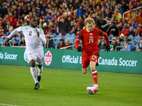 J. Shaffelburg #14 carries the ball while Myenty Abena #12 chases him at the CONCACAF Nations League Quarter Final Match between Team Canada...