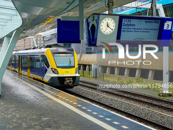 At Arnhem Centraal station in Arnhem, Netherlands, on July 27, 2023, a bright yellow-blue Sprinter train prepares to depart for Zutphen. The...