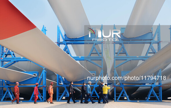 Police check the blades of offshore wind turbines stored at a port in Dongying City, East China, on November 20, 2024. 