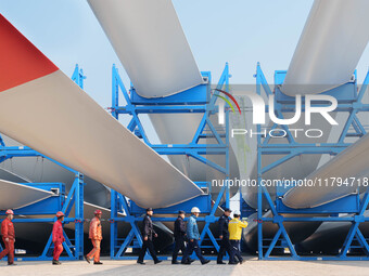 Police check the blades of offshore wind turbines stored at a port in Dongying City, East China, on November 20, 2024. (