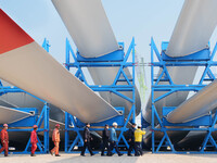 Police check the blades of offshore wind turbines stored at a port in Dongying City, East China, on November 20, 2024. (