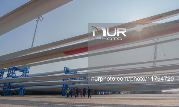 Police check the blades of offshore wind turbines stored at a port in Dongying City, East China, on November 20, 2024. 