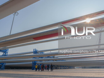 Police check the blades of offshore wind turbines stored at a port in Dongying City, East China, on November 20, 2024. (