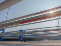 Police check the blades of offshore wind turbines stored at a port in Dongying City, East China, on November 20, 2024. (