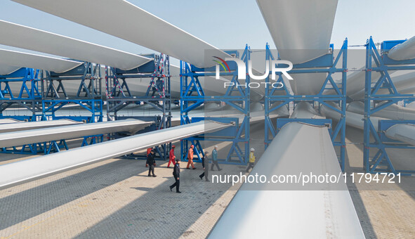 Police check the blades of offshore wind turbines stored at a port in Dongying City, East China, on November 20, 2024. 