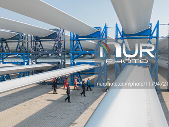 Police check the blades of offshore wind turbines stored at a port in Dongying City, East China, on November 20, 2024. (