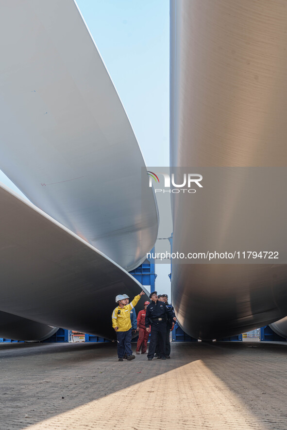 Police check the blades of offshore wind turbines stored at a port in Dongying City, East China, on November 20, 2024. 