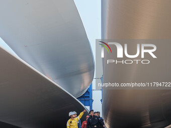 Police check the blades of offshore wind turbines stored at a port in Dongying City, East China, on November 20, 2024. (