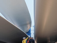 Police check the blades of offshore wind turbines stored at a port in Dongying City, East China, on November 20, 2024. (