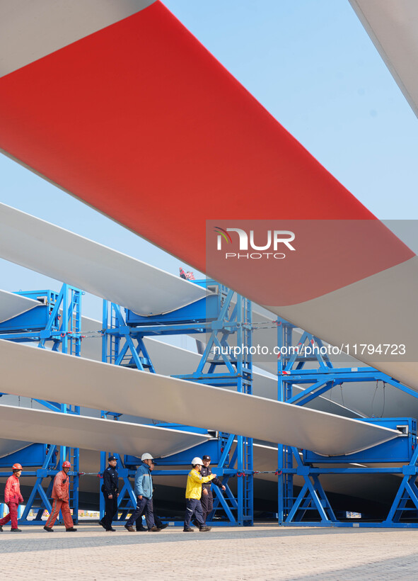 Police check the blades of offshore wind turbines stored at a port in Dongying City, East China, on November 20, 2024. 