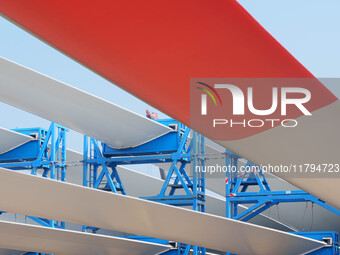 Police check the blades of offshore wind turbines stored at a port in Dongying City, East China, on November 20, 2024. (