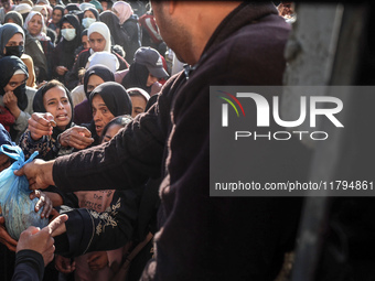 Palestinians wait in a queue to receive bread outside a bakery in Khan Yunis, on November 20, 2024, amid the ongoing war between Israel and...