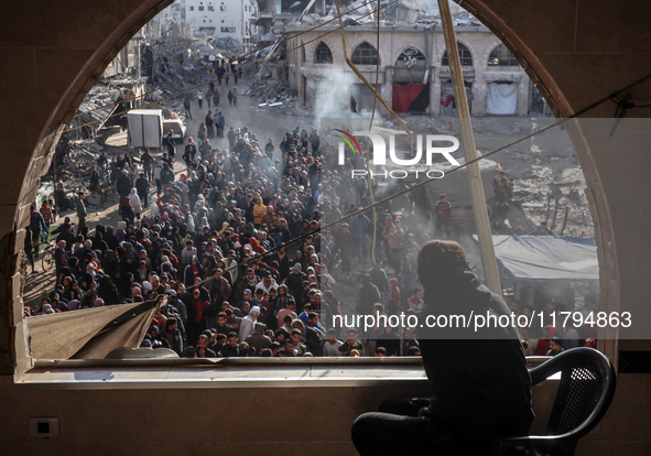 Palestinians wait in a queue to receive bread outside a bakery in Khan Yunis, on November 20, 2024, amid the ongoing war between Israel and...