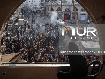 Palestinians wait in a queue to receive bread outside a bakery in Khan Yunis, on November 20, 2024, amid the ongoing war between Israel and...