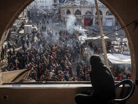 Palestinians wait in a queue to receive bread outside a bakery in Khan Yunis, on November 20, 2024, amid the ongoing war between Israel and...