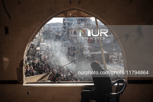 Palestinians wait in a queue to receive bread outside a bakery in Khan Yunis, on November 20, 2024, amid the ongoing war between Israel and...