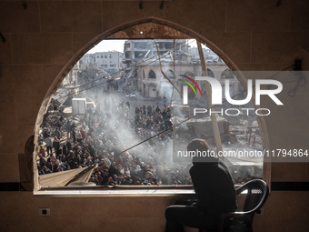 Palestinians wait in a queue to receive bread outside a bakery in Khan Yunis, on November 20, 2024, amid the ongoing war between Israel and...