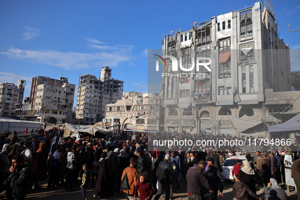 Palestinians wait in a queue to receive bread outside a bakery in Khan Yunis, on November 20, 2024, amid the ongoing war between Israel and...