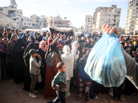 Palestinians wait in a queue to receive bread outside a bakery in Khan Yunis, on November 20, 2024, amid the ongoing war between Israel and...