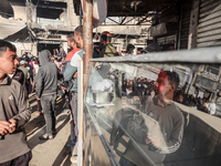 Palestinians wait in a queue to receive bread outside a bakery in Khan Yunis, on November 20, 2024, amid the ongoing war between Israel and...