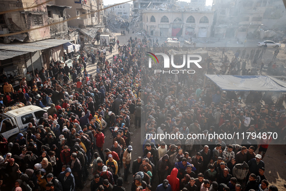 Palestinians wait in a queue to receive bread outside a bakery in Khan Yunis, on November 20, 2024, amid the ongoing war between Israel and...