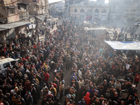 Palestinians wait in a queue to receive bread outside a bakery in Khan Yunis, on November 20, 2024, amid the ongoing war between Israel and...