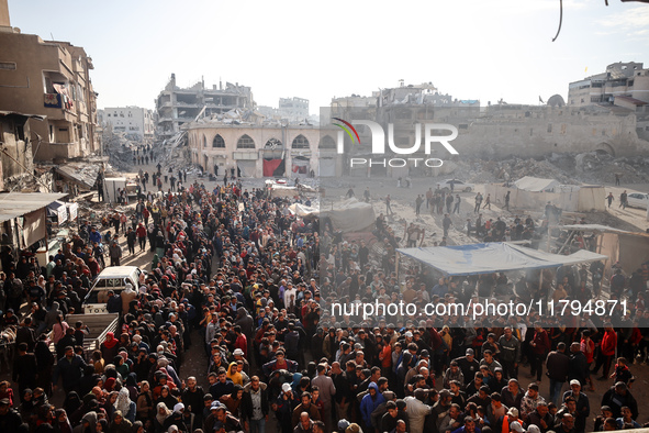 Palestinians wait in a queue to receive bread outside a bakery in Khan Yunis, on November 20, 2024, amid the ongoing war between Israel and...